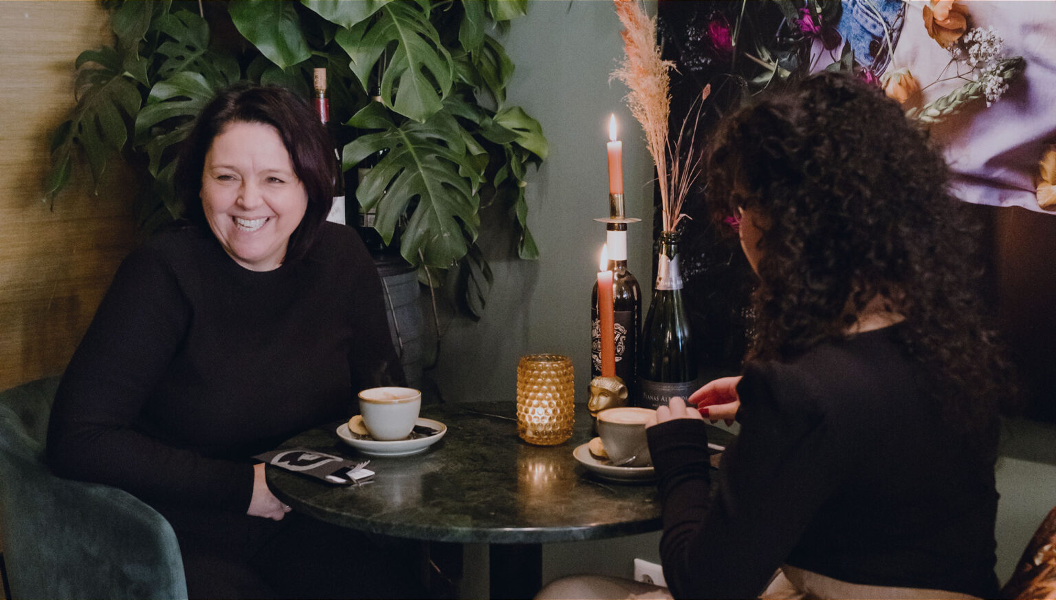 Twee gasten aan een marmeren tafeltje met koffie bij daglicht